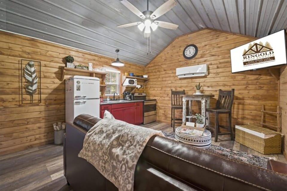 Living room has smart TV and dining table and stools