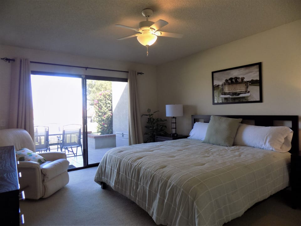 Primary bedroom includes cable TV, vanity and direct access to the patio