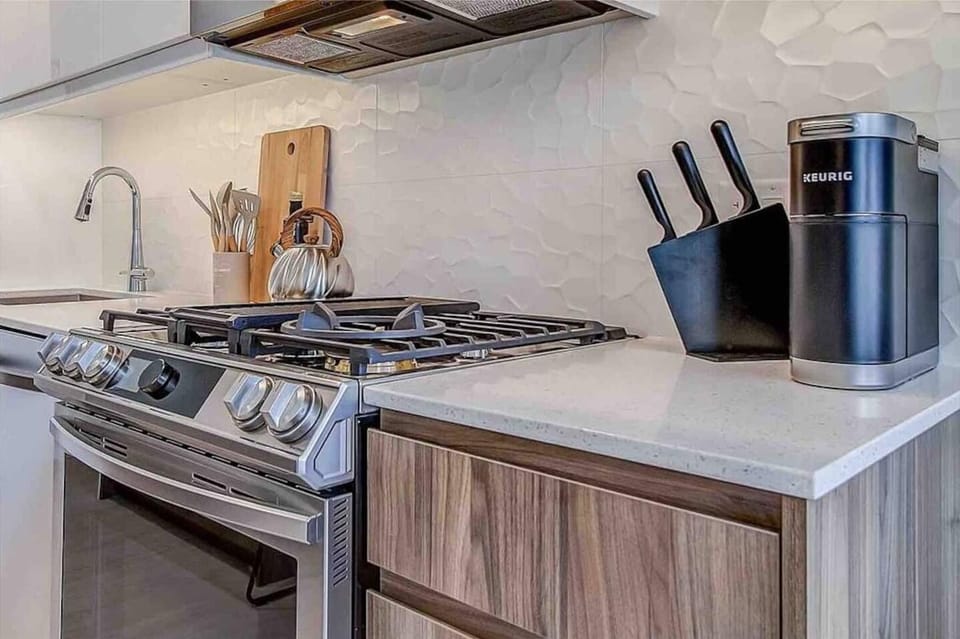 Long kitchen island with seating for 4 and plenty of prep space for those who love to cook at home. All new high-end appliances, including a touch-screen oven that you can control from your phone. 