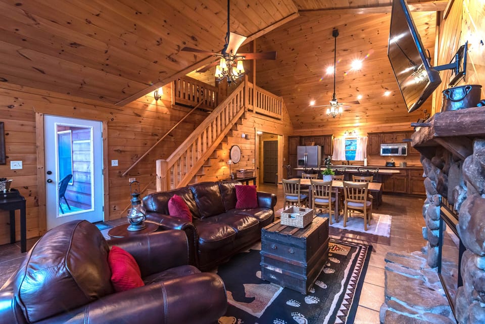 Living room with view of door leading to upper deck with grill.