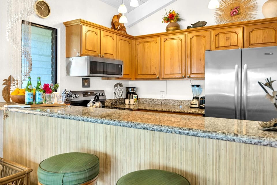 Fully equipped kitchen with granite countertops and stainless steel appliances—perfect for home-cooked island meals.