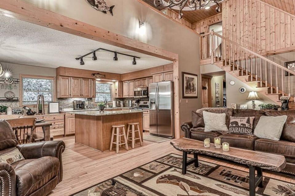 Details matter in a cabin stay and nothing was left undone in this two-story living room space.  From the antler chandelier to the live edge wood coffee table to the recliner, relax in Buddy`s Bungalow.