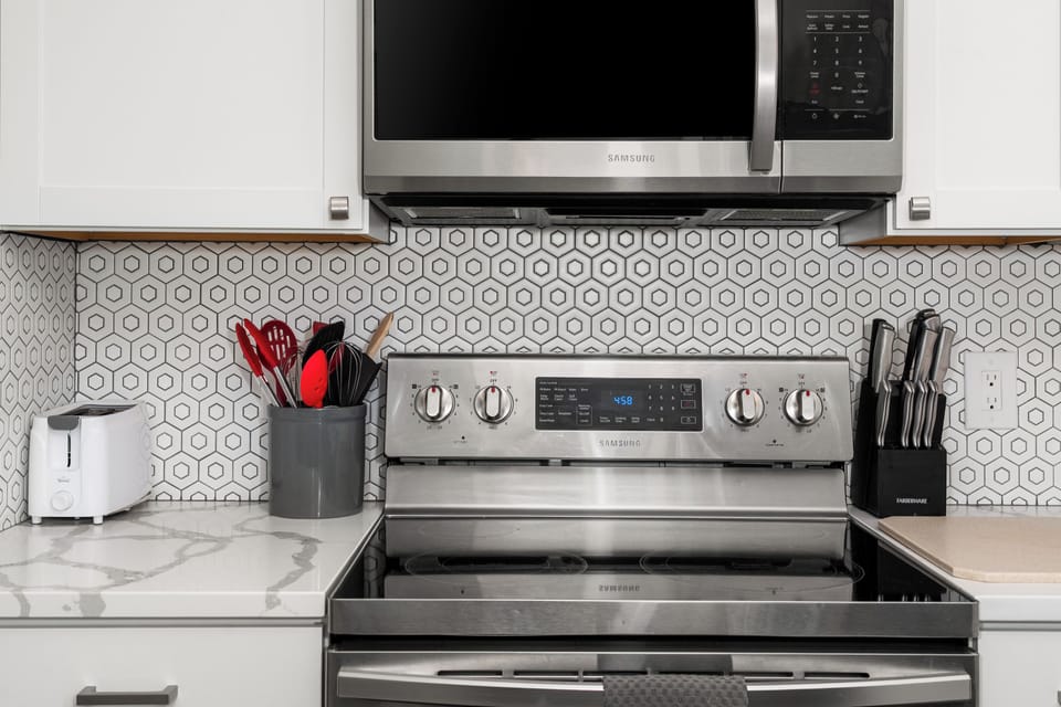 Modern kitchen with stainless appliances and stylish tile backsplash