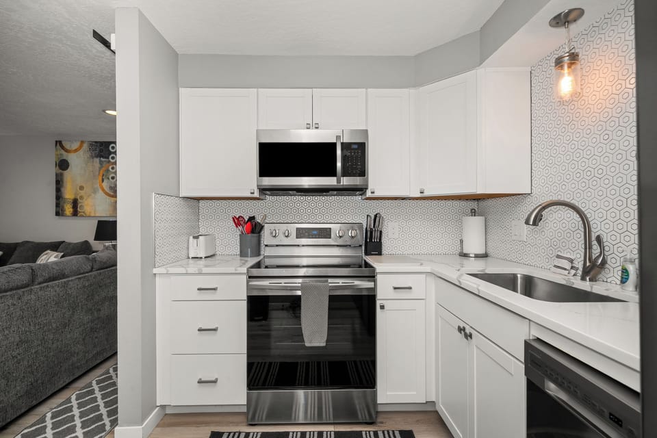 Bright modern kitchen with stainless appliances and stylish tile backsplash