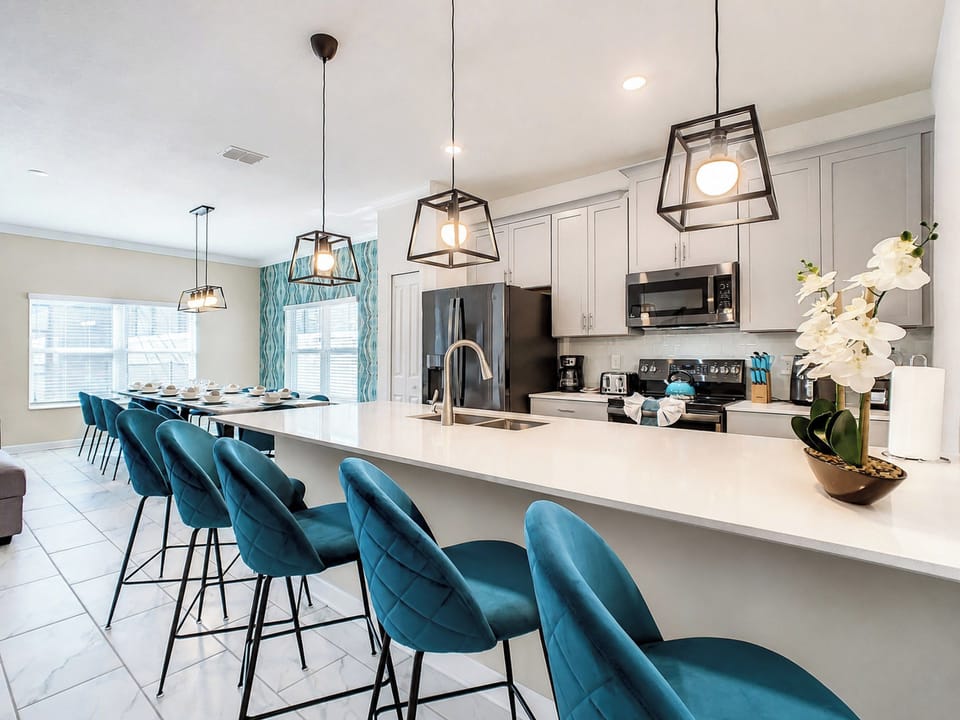 Modern Kitchen Island with Velvet Bar Seating and Sleek Lighting
