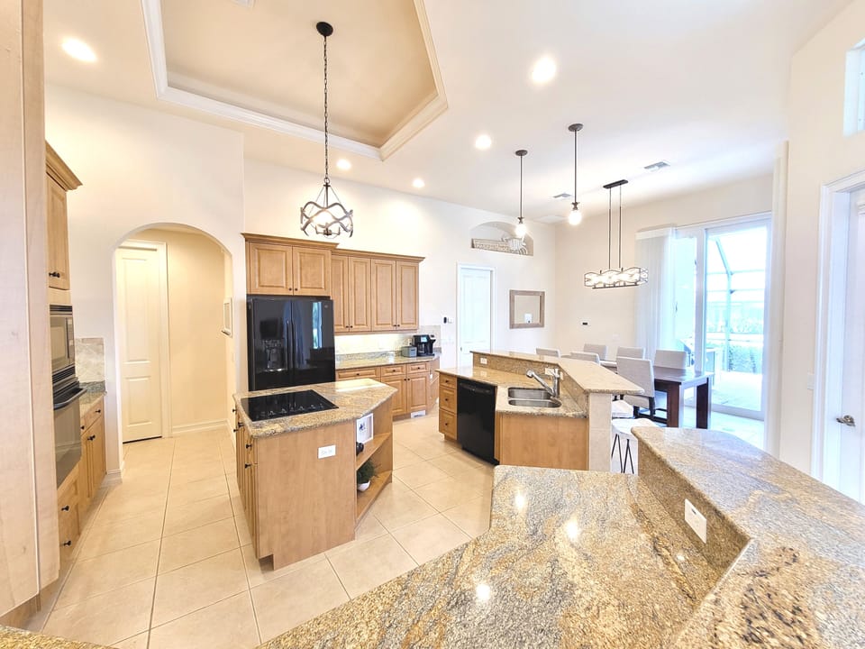 Kitchen into dining area. You can also use desk/spare den chair for dining table
