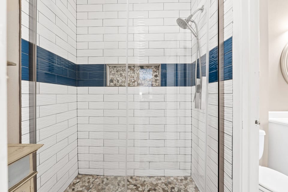 Shared bathroom featuring a sleek walk-in tile shower.