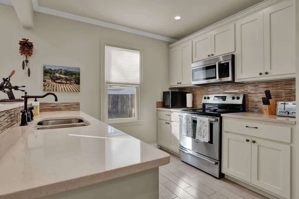Fully stocked kitchen with island seating and a nearby dining table, giving groups plenty of space to gather for meals or drinks.