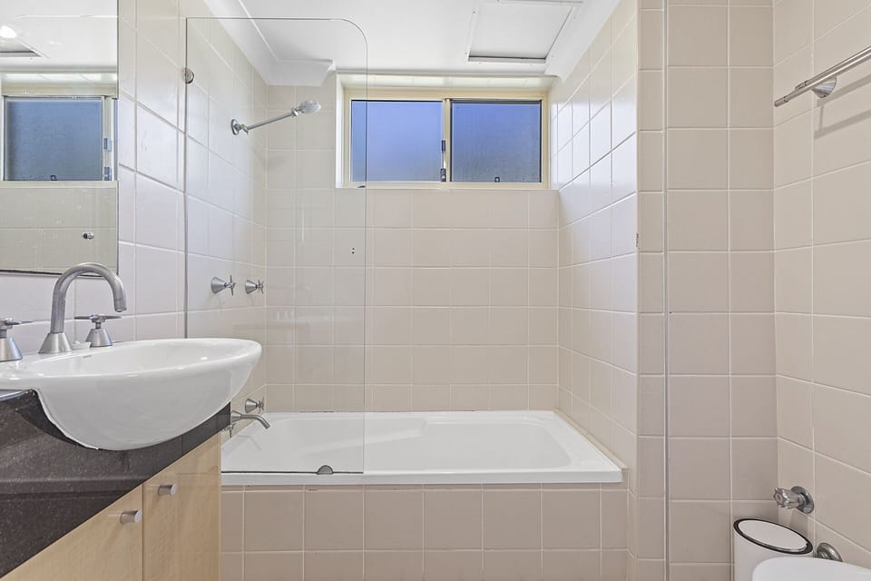Main bedroom with shower over the bathtub, toilet also in this room.