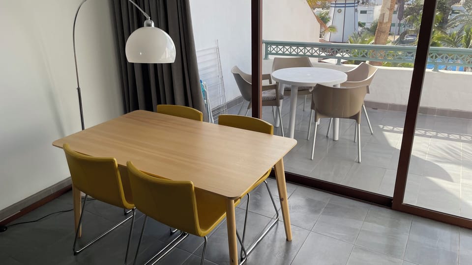 Dining table and chairs, leading to sea-view balcony