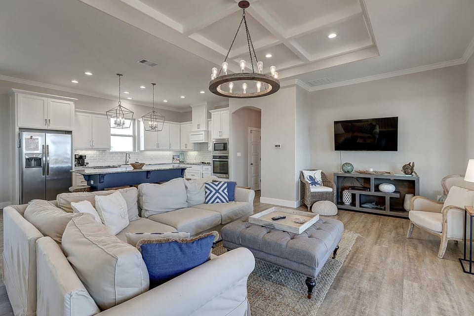Sink into plush sofas in your open-concept haven where coastal elegance meets modern comfort—perfect for unwinding after exploring.
