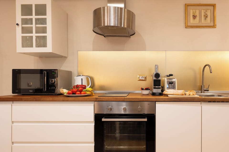 KItchen with microwave, oven and set for preparing tea and coffee.