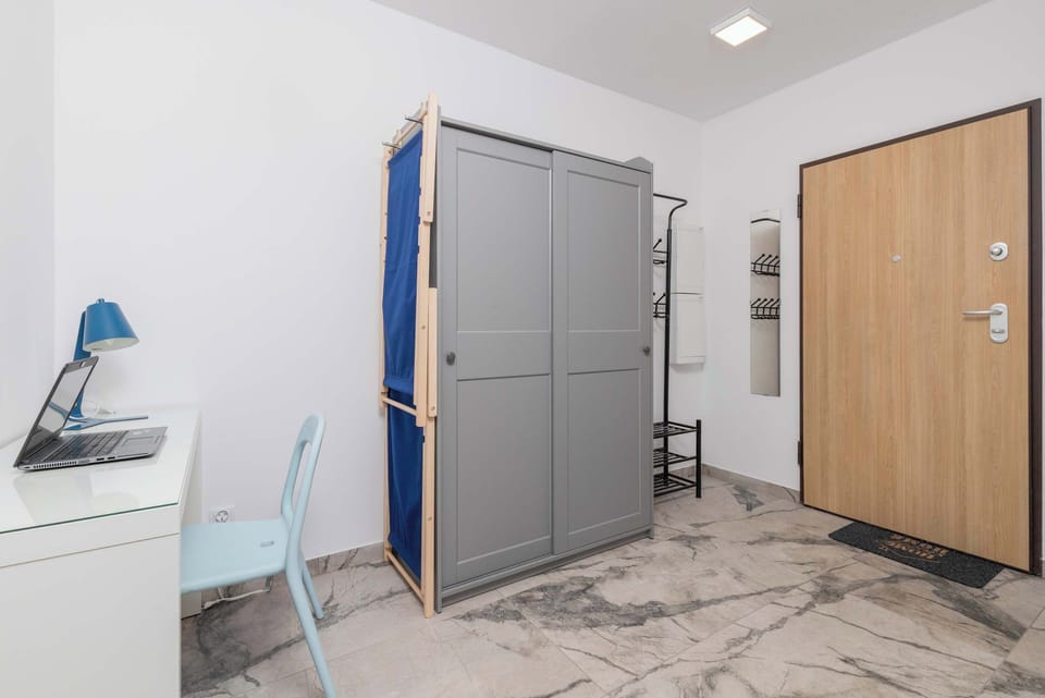 Hallway with closet and desk with chair for remote work.