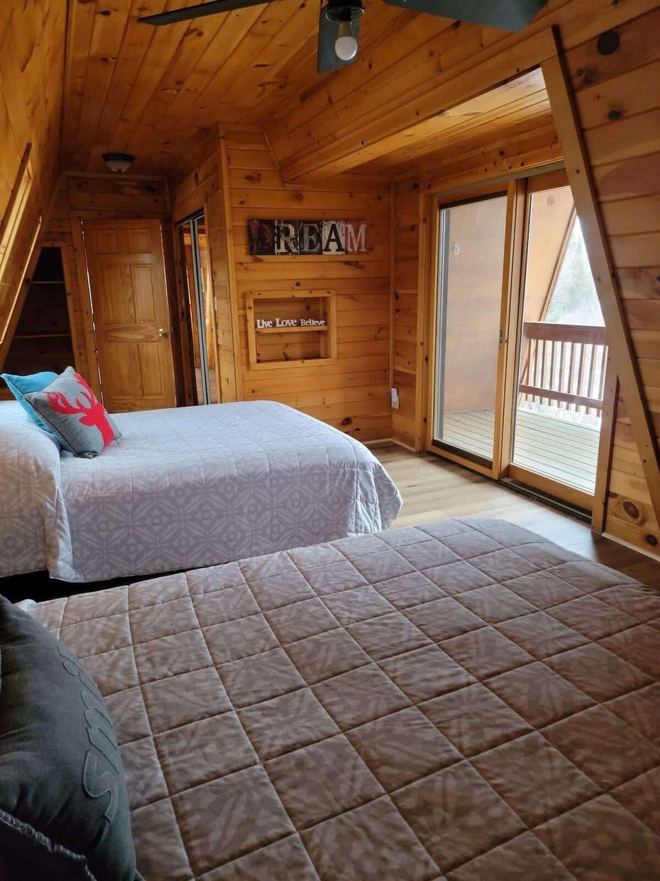 Upstairs bedroom features two queen beds in one room. Also features a balcony that overlooks the lake. 