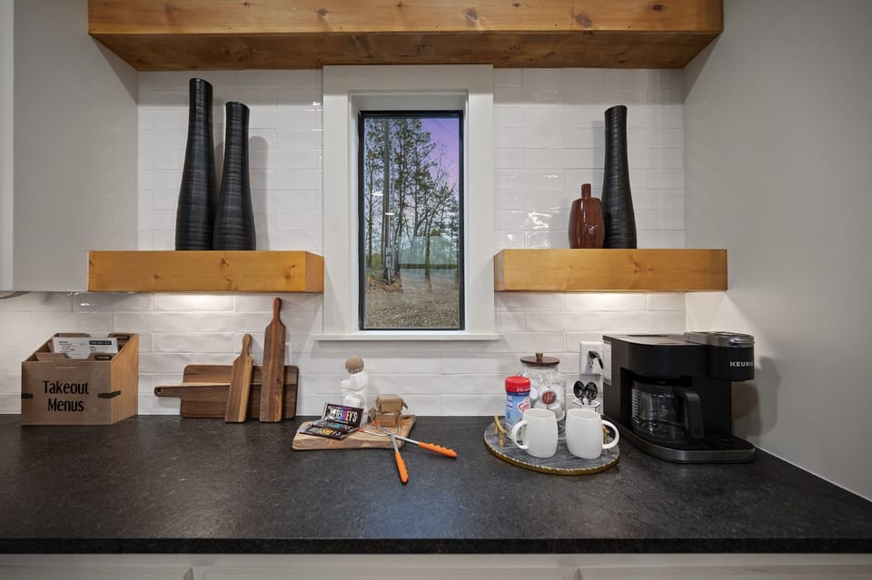 Morning Delight: Start your day with a perfectly brewed cup from our fully stocked coffee station, a cozy nook that frames the serene outdoor greenscape.  