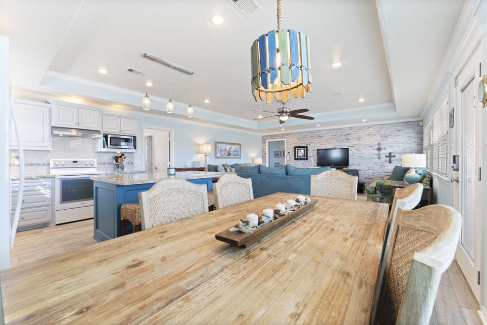 Seats 12 people at the dining room table and kitchen island plus a high chair. 