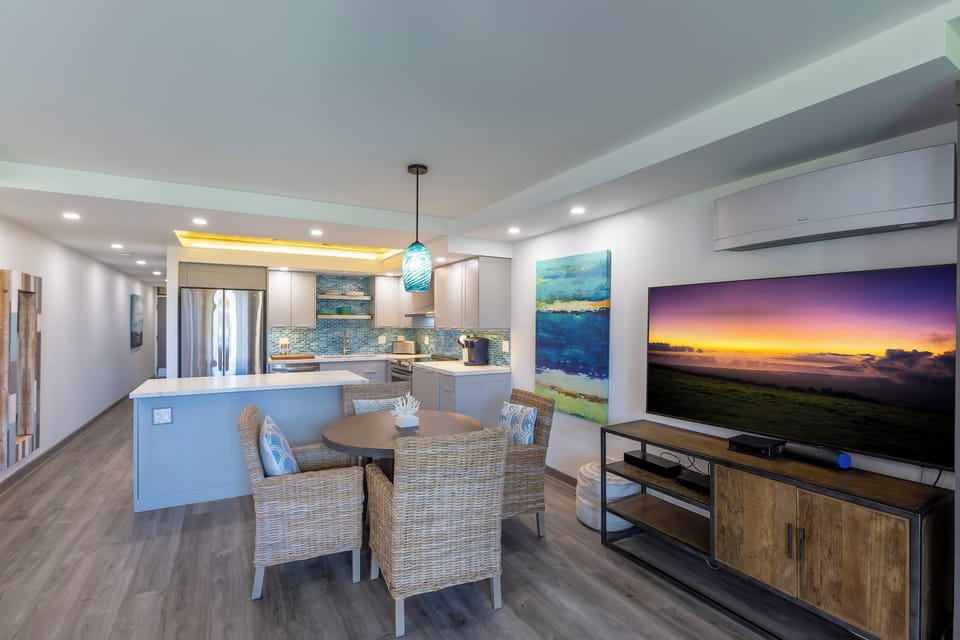 Step into your light-filled retreat where the open layout seamlessly blends kitchen, dining, and living spaces. Relax at the coastal-inspired dining table or unwind in comfort with modern amenities and breezy, beach-inspired décor welcoming you home.
