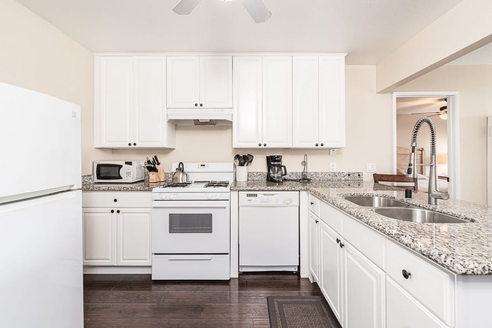 Beyond the living area is the kitchen, which comes stocked with dishes, utensils, cookware, bakeware, and large and small appliances.
                