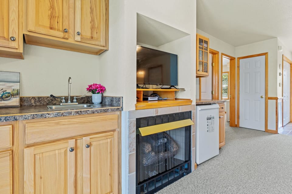 Relaxed den with entertainment center and wet bar. (Please note: Fireplace is not for guest use)