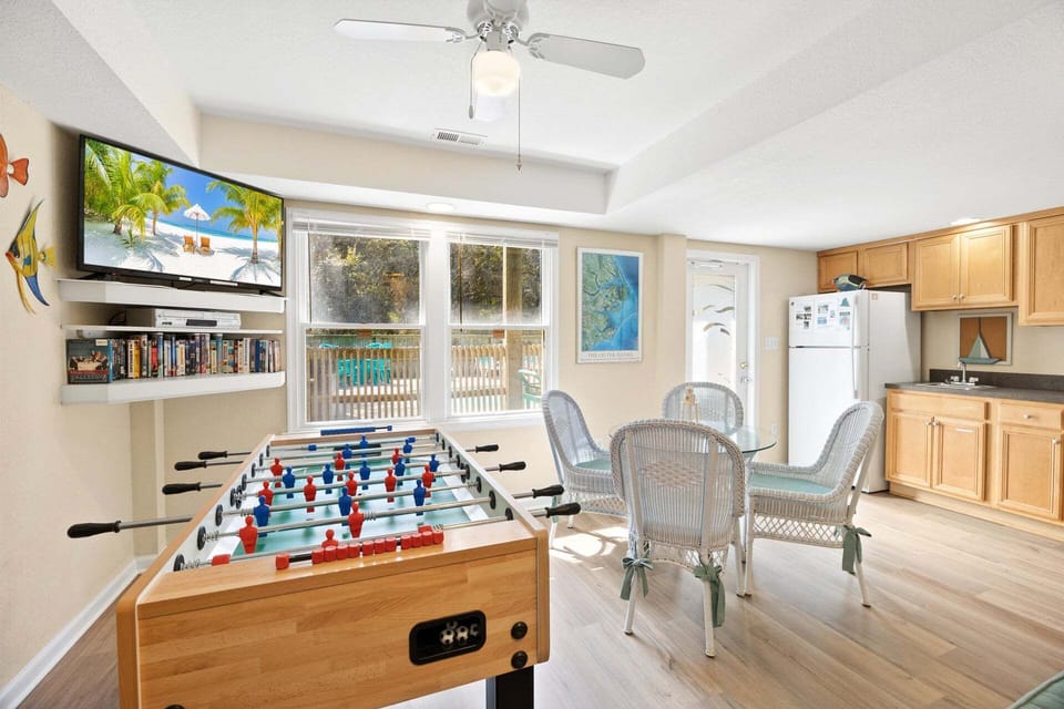 The ground-level recreation room features a foosball table and flat-screen TV for indoor entertainment.