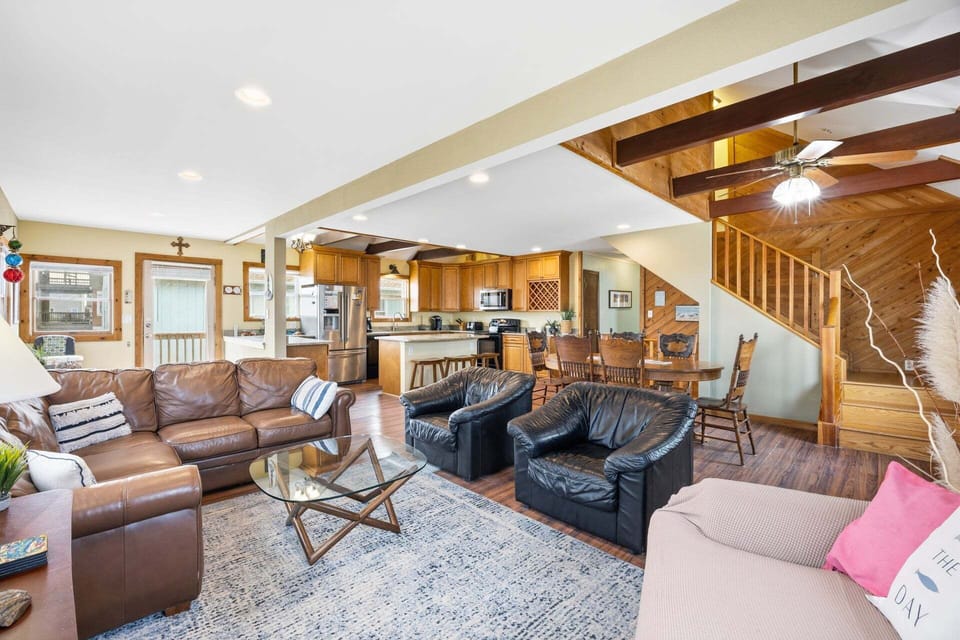 The spacious living area features comfortable furnishings and warm wood accents for a cozy coastal feel.