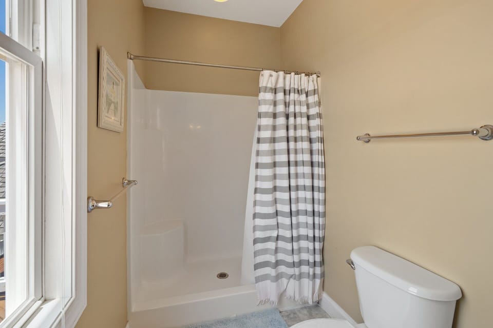 The top-level King ensuite bedroom offers a private full bath and direct access to the oceanfront sun deck, ideal for enjoying morning coffee or evening sunsets.