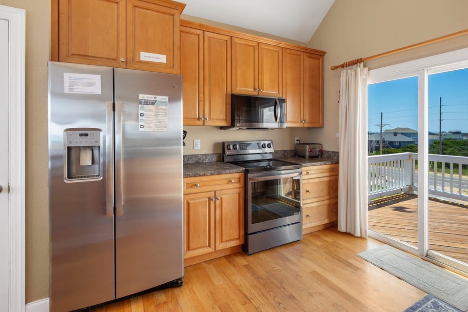 The modern, fully equipped kitchen includes a corner bar with seating for five, a wine rack, and all the appliances needed to prepare delicious meals.