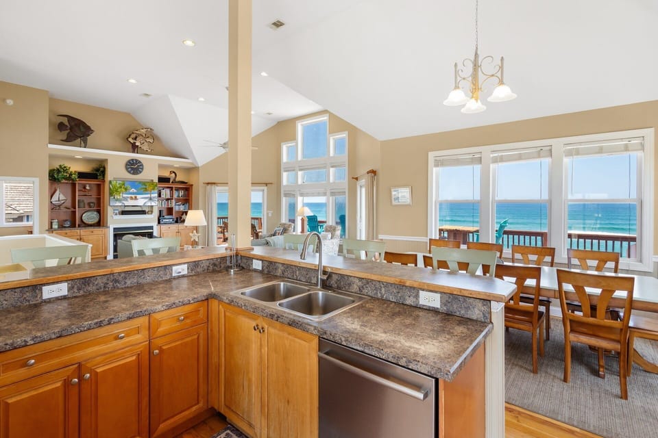The modern, fully equipped kitchen includes a corner bar with seating for five, a wine rack, and all the appliances needed to prepare delicious meals.