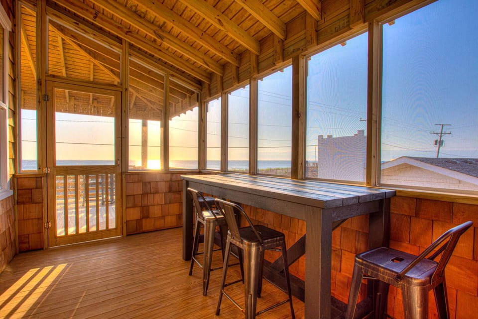 The screened-in porch offers a perfect setting for alfresco dining or enjoying the ocean breeze without the worry of insects.