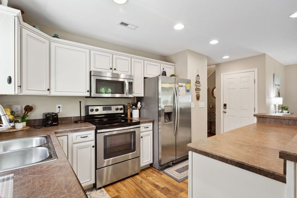 Prepare delicious meals at home in the spacious kitchen with stainless steel appliances, beautiful white cabinets, and plenty of prep space.