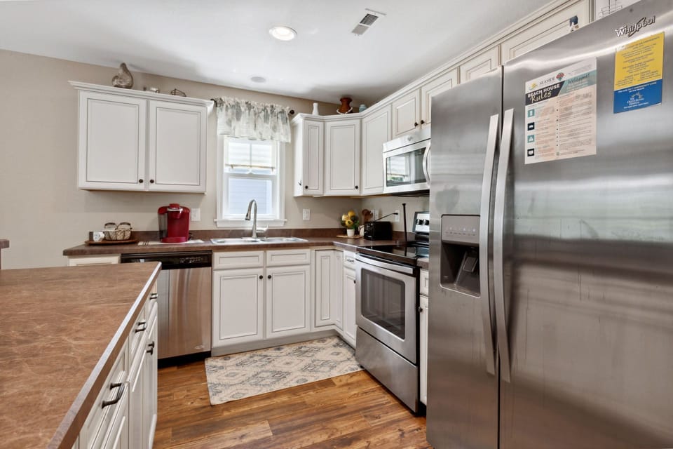 Prepare delicious meals at home in the spacious kitchen with stainless steel appliances, beautiful white cabinets, and plenty of prep space.