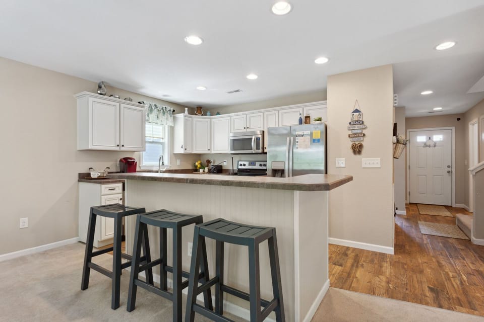Prepare delicious meals at home in the spacious kitchen with stainless steel appliances, beautiful white cabinets, and plenty of prep space.