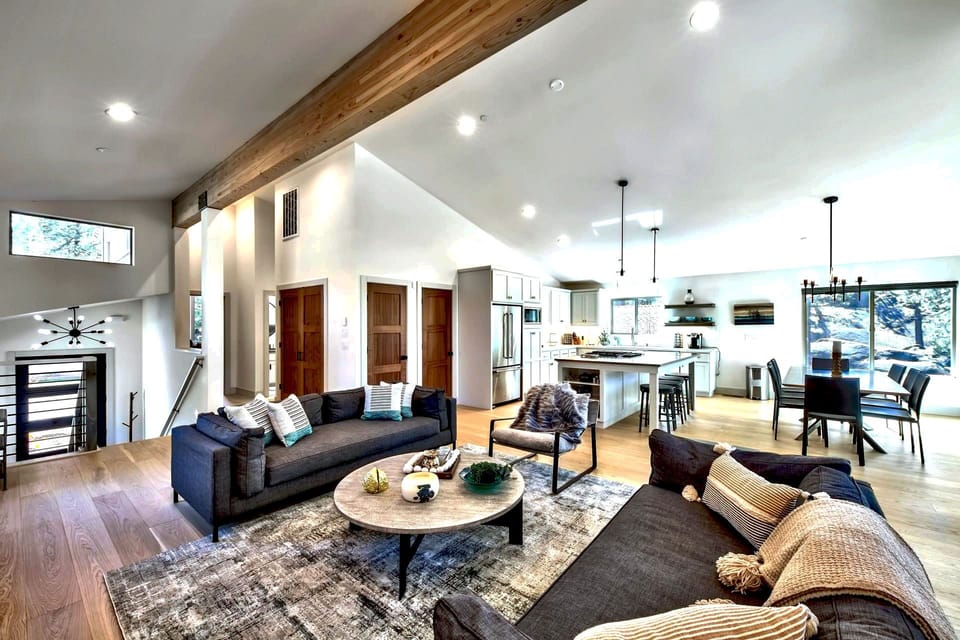 A spacious living room with a large table and plush couches, perfect for gatherings and relaxing in luxurious comfort.