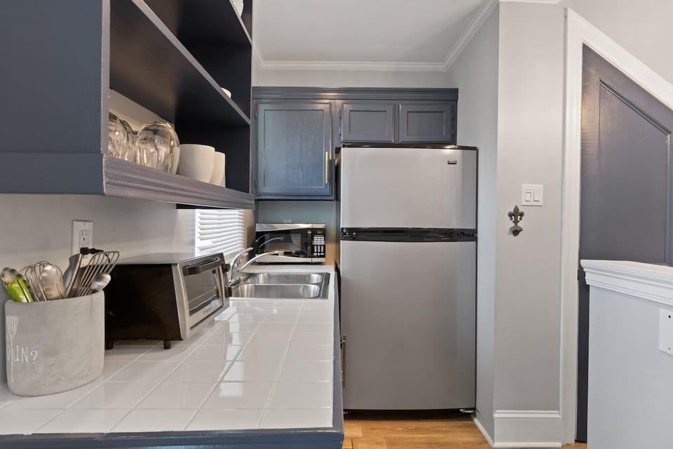 Fully stocked kitchen w/ stainless steel fridge & sleek cabinetry.
