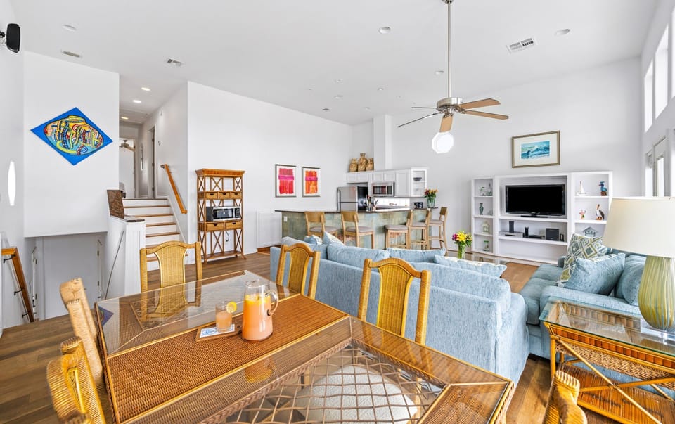 Dining Area — Wicker Chairs, Blue Sofas & Fish Art with Staircase