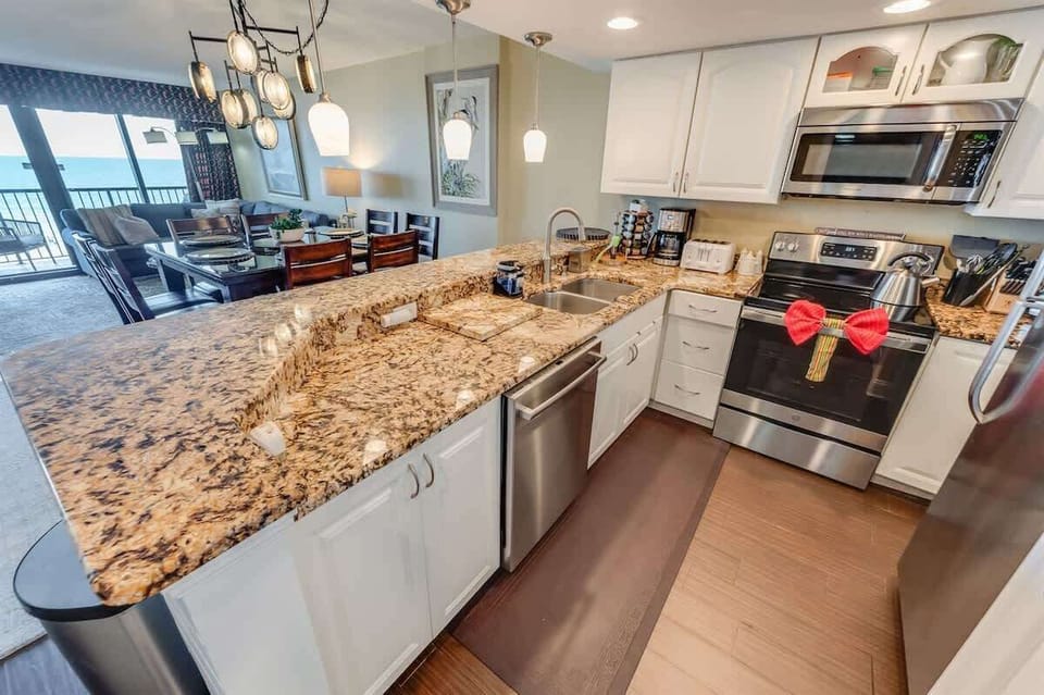 - Equipped kitchen with granite countertops & stainless steel appliances - Open concept design flows into the dining & living area, perfect for entertaining with ocean views - Stocked with cookware, coffee maker & essentials to make mealtime effortle