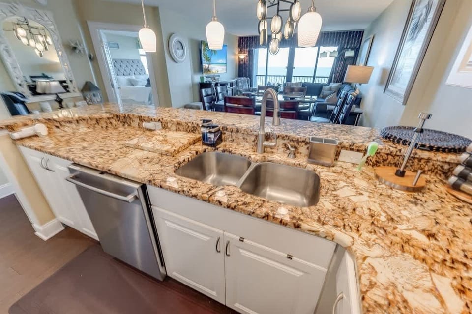 - Stunning open concept kitchen with granite countertops and ocean views in the background - Double sink, dishwasher, and extra counter space make meal prep effortless - Designed for gathering, with a seamless flow to the dining and living areas