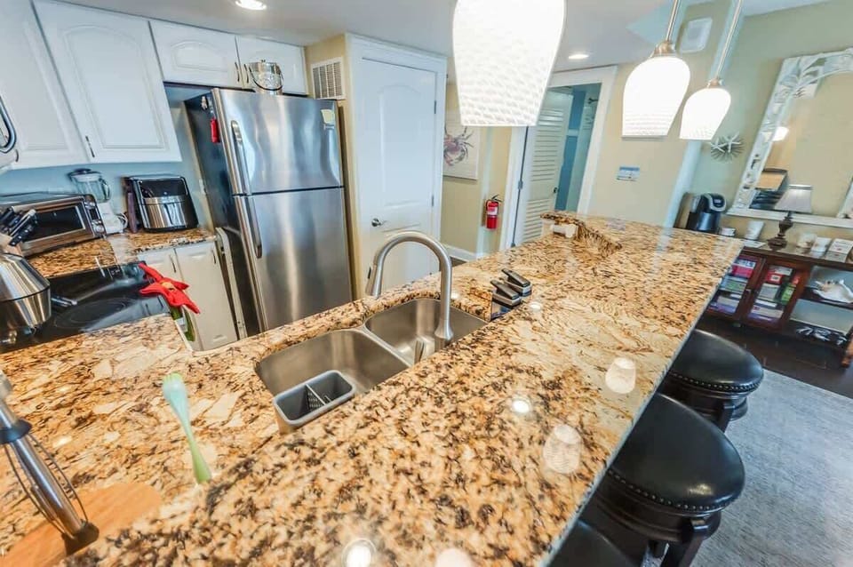 - Spacious kitchen island with bar seating, perfect for casual dining or morning coffee - Fully equipped with stainless steel appliances & all the essentials for home cooked meals - Modern lighting & warm granite surfaces create a welcoming space to