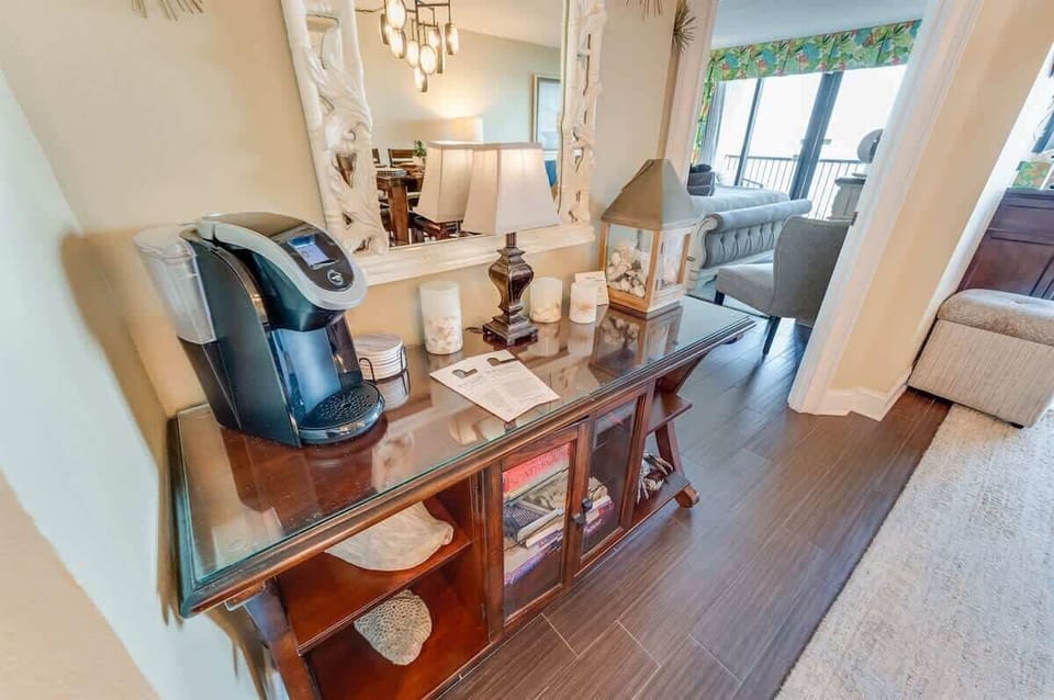 - Start your day with a fresh brew at this coffee station, complete with a Keurig & cozy décor - Stylish console with books, candles & coastal accents adds warmth to the space - Thoughtfully placed near the dining area, making every morning more conv