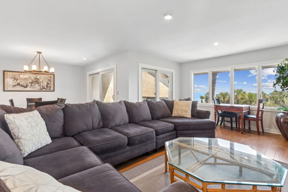 Expansive Living room sofa area with window & sliding doors to patio