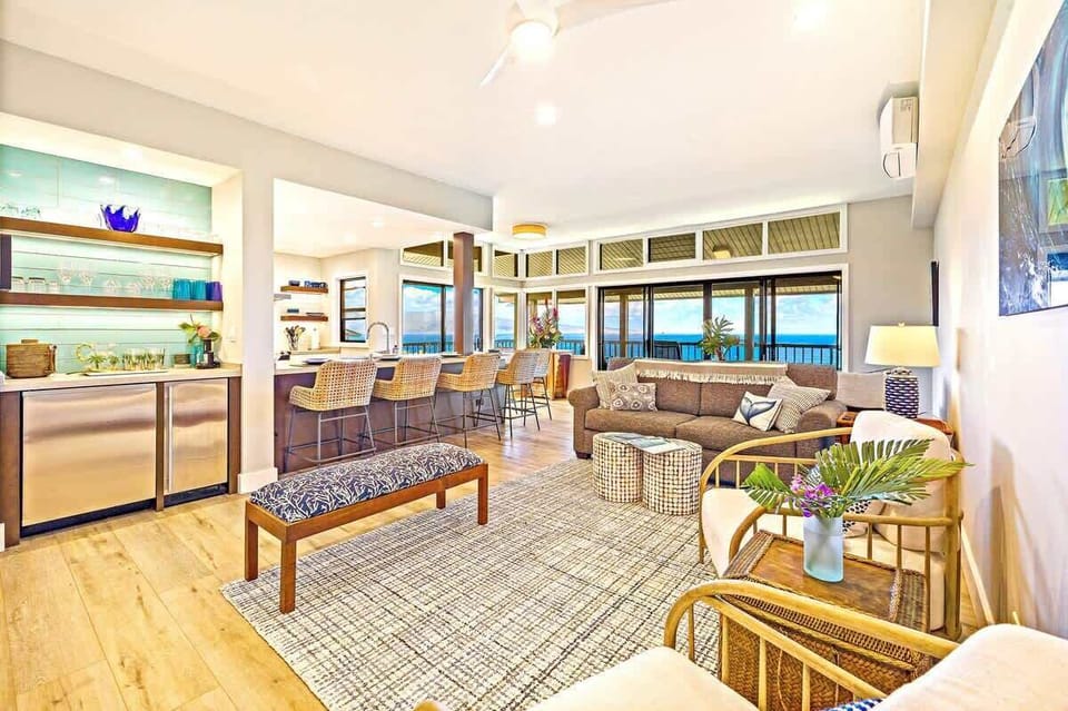Bright and modern living space with coastal-inspired décor, plush sectional sofa, and stylish bar area. Reference "ocean view" in your inquiry and get 5% off the nightly through December 15th, 2025! 