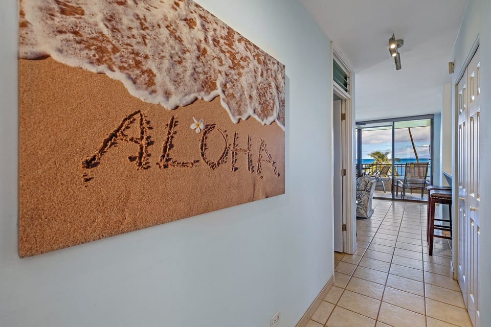 Walk into paradise with this welcoming hallway featuring a stunning "Aloha" sand print, setting the perfect tone for a relaxed Hawaiian getaway.