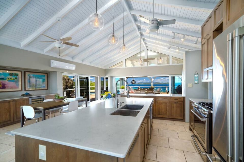 The spacious and well-appointed kitchen with full AC, kitchen island, and bar stools.