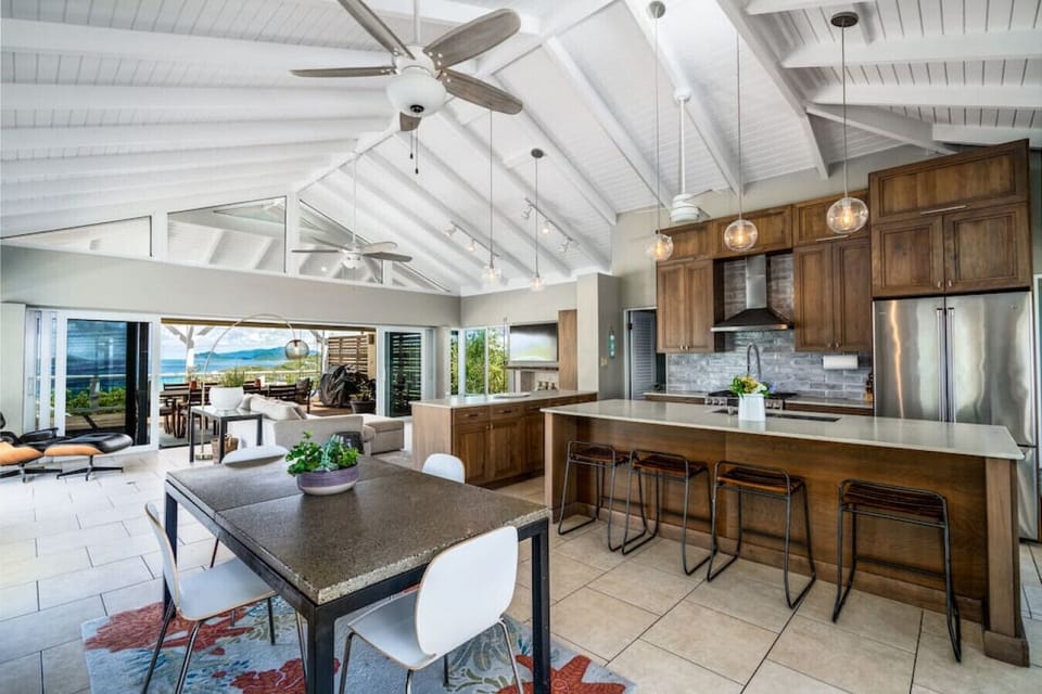 The spacious kitchen and dining area with full AC - and living room in the background.