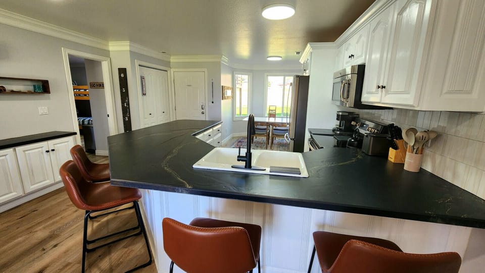 Bright, open kitchen with large island, modern appliances, and cozy dining nook perfect for gatherings