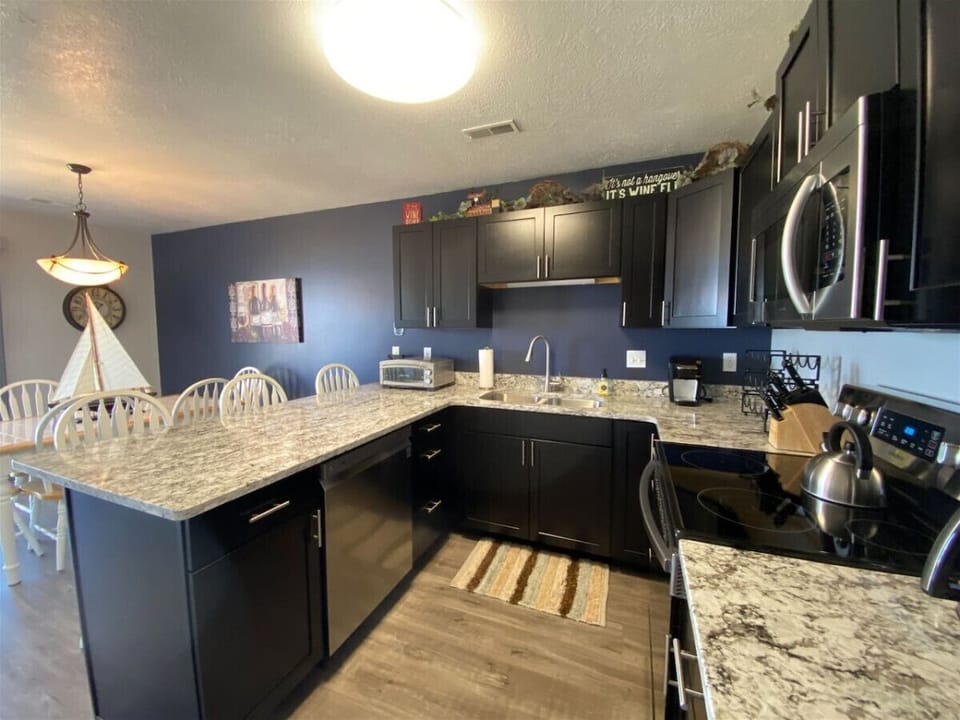 Modern kitchen with granite countertops, stainless appliances, and ample space
