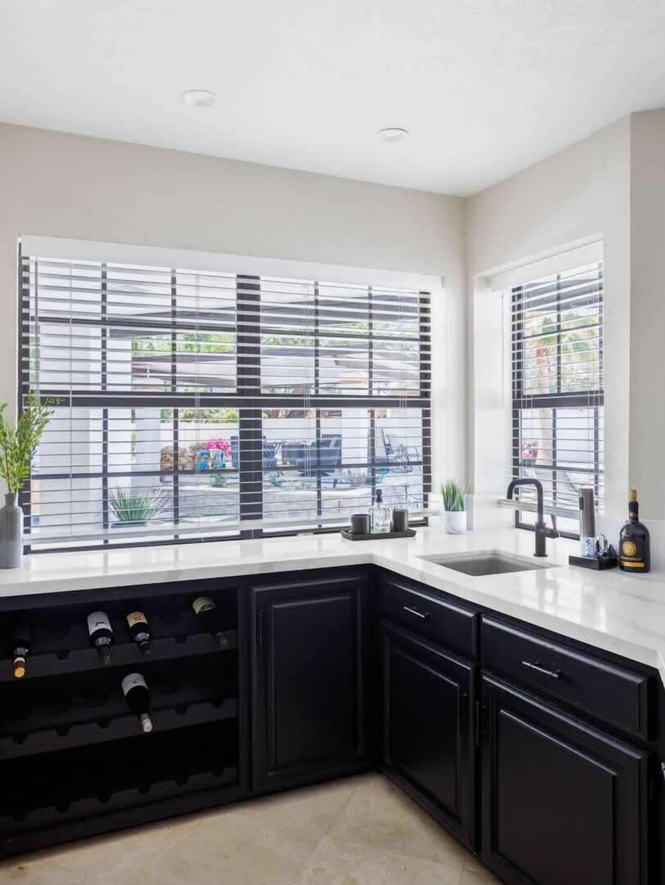 Additional living space features a smart flat-screen TV, designer furnishings, an electric fireplace, and a wet bar area. (1st Floor)