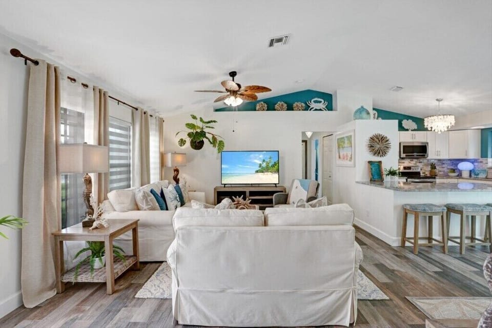 Bright living area with cozy seating and open kitchen, perfect for relaxing and entertaining.