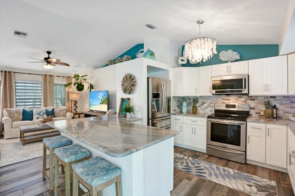 Open-concept kitchen and living area with modern appliances and cozy seating.