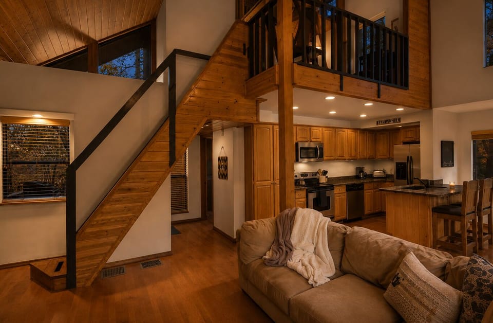 Open living, dining, and deck view from loft inside cabin